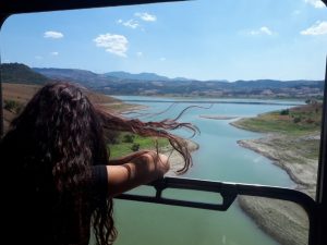 Ragazza affacciata su treno che attraversa il paesaggio dell'Irpinia